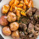 Pressure Cooker Pot Roast in white bowl with potatoes and carrots