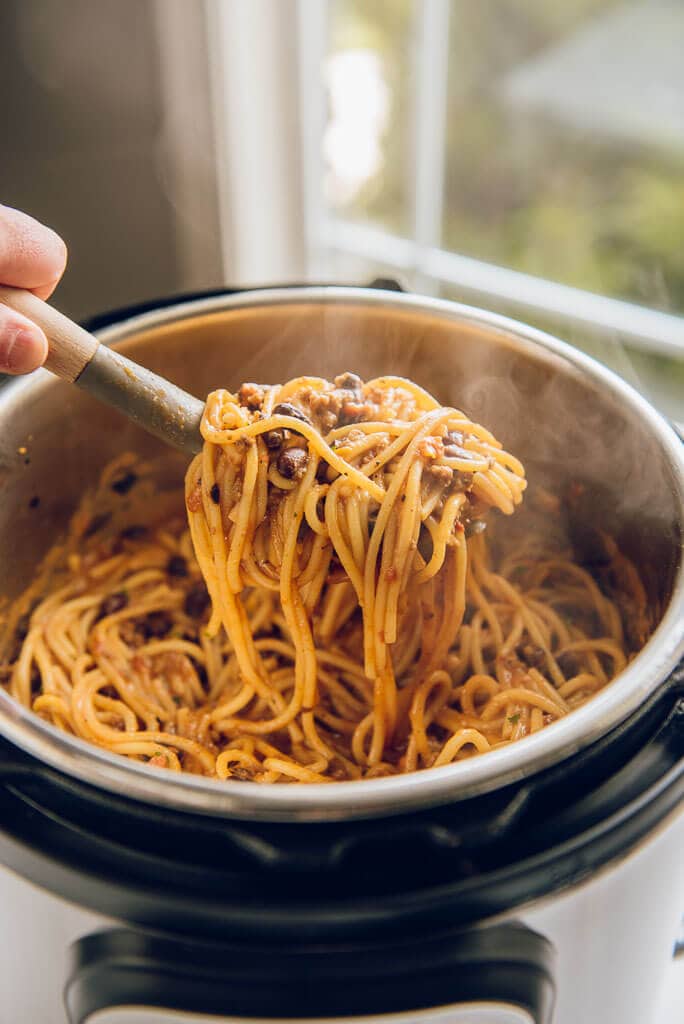 Instant Pot Taco Spaghetti being scooped out of pressure cooker with a spaghetti fork