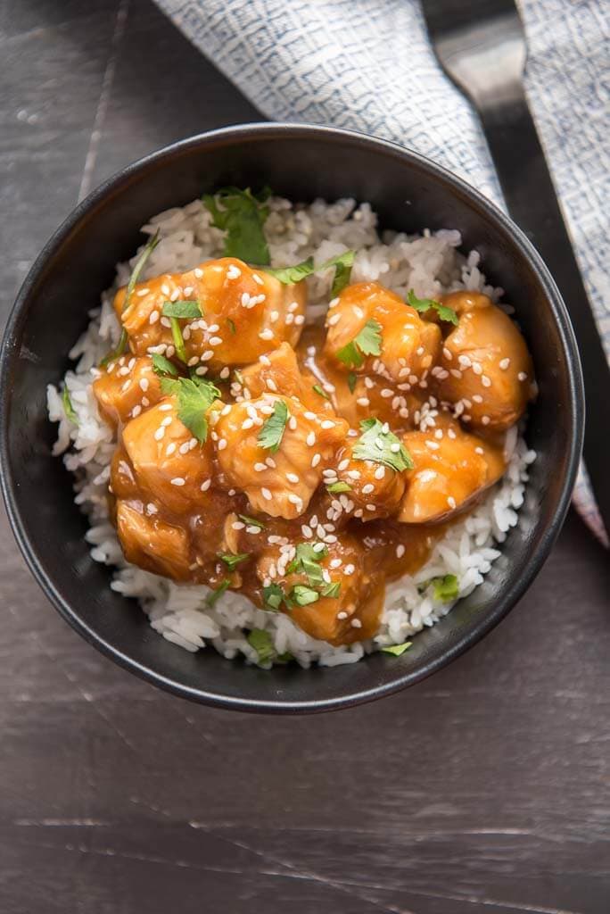 looking down at instant pot sesame chicken over rice in black bowl