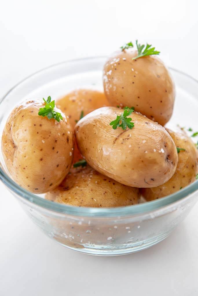 several slow cooker baked potatoes in glass bowl