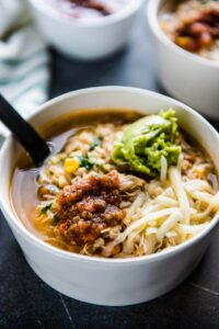 chipotle chicken burrito bowl soup in white bowls with a bowl of salsa