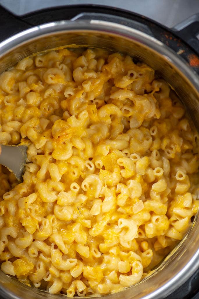 butternut squash Mac and cheese in instant pot with spoon to stir