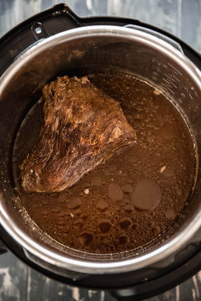 instant pot with cooked beef and juice for French dips