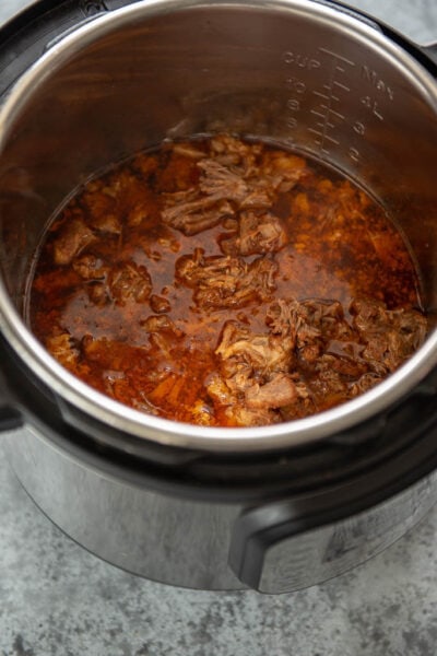 cooked pulled pork in juices in the Instant Pot
