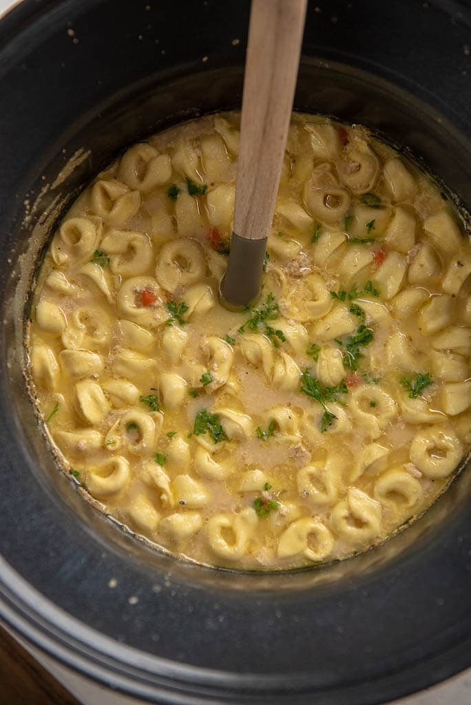 chicken tortellini soup in slow cooker with ladle 