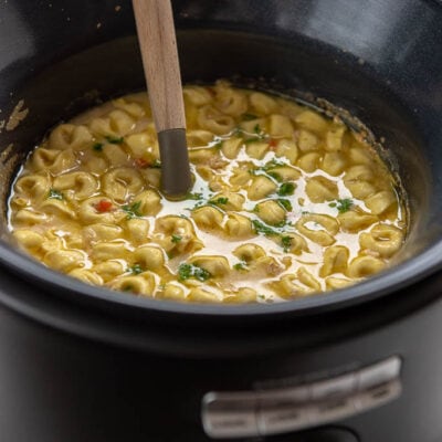 chicken tortellini soup in slow cooker with ladle