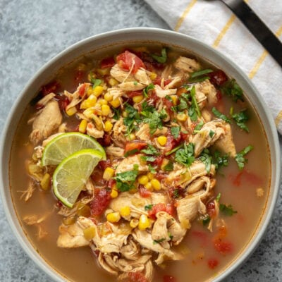 gray bowl full of spicy chicken soup topped with cilantro