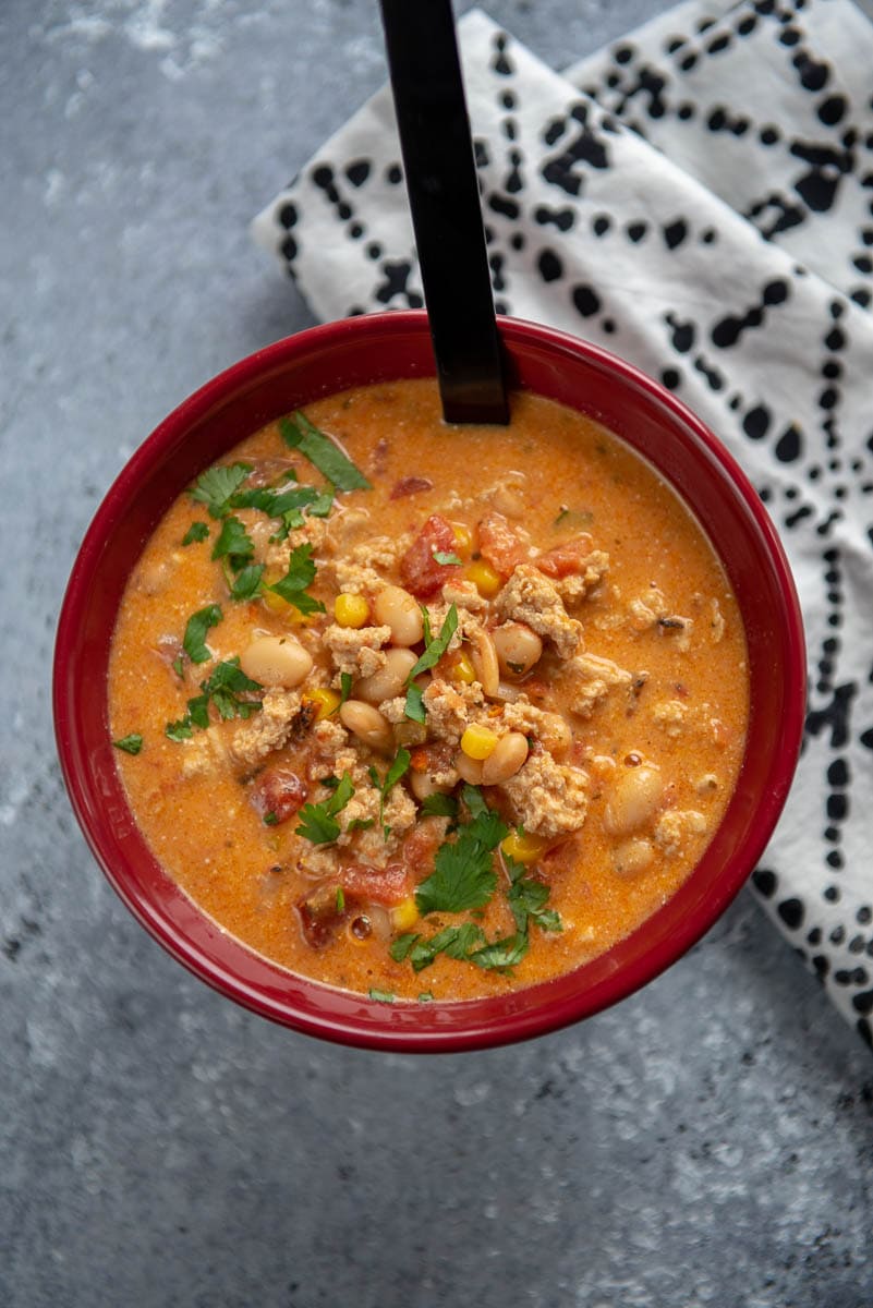 red bowl with instant pot chili topped with cilantro