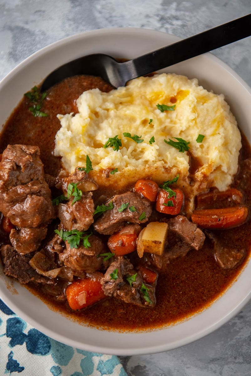 bowl filled with mashed potatoes and beef stew