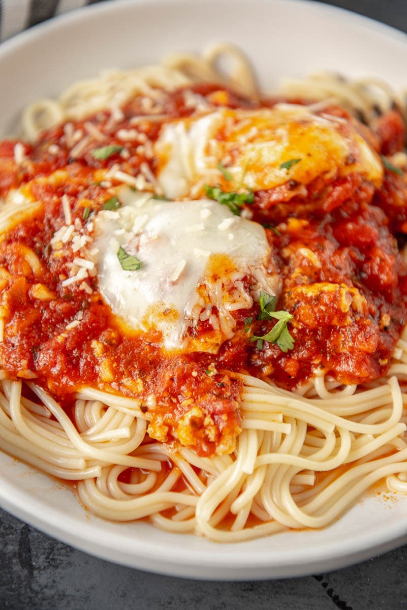 chicken parmesan meatballs with marinara and pasta in a bowl