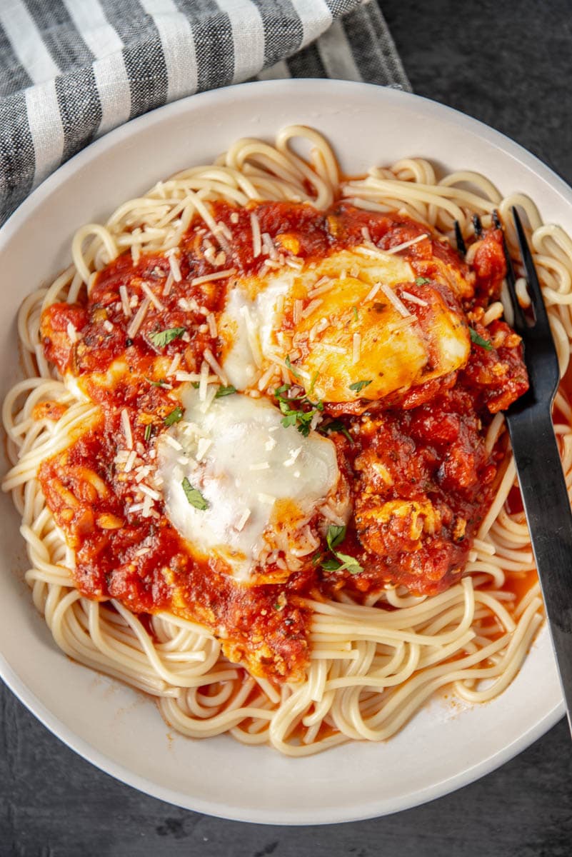 chicken meatballs in bowl of spaghetti topped with marinara and cheese