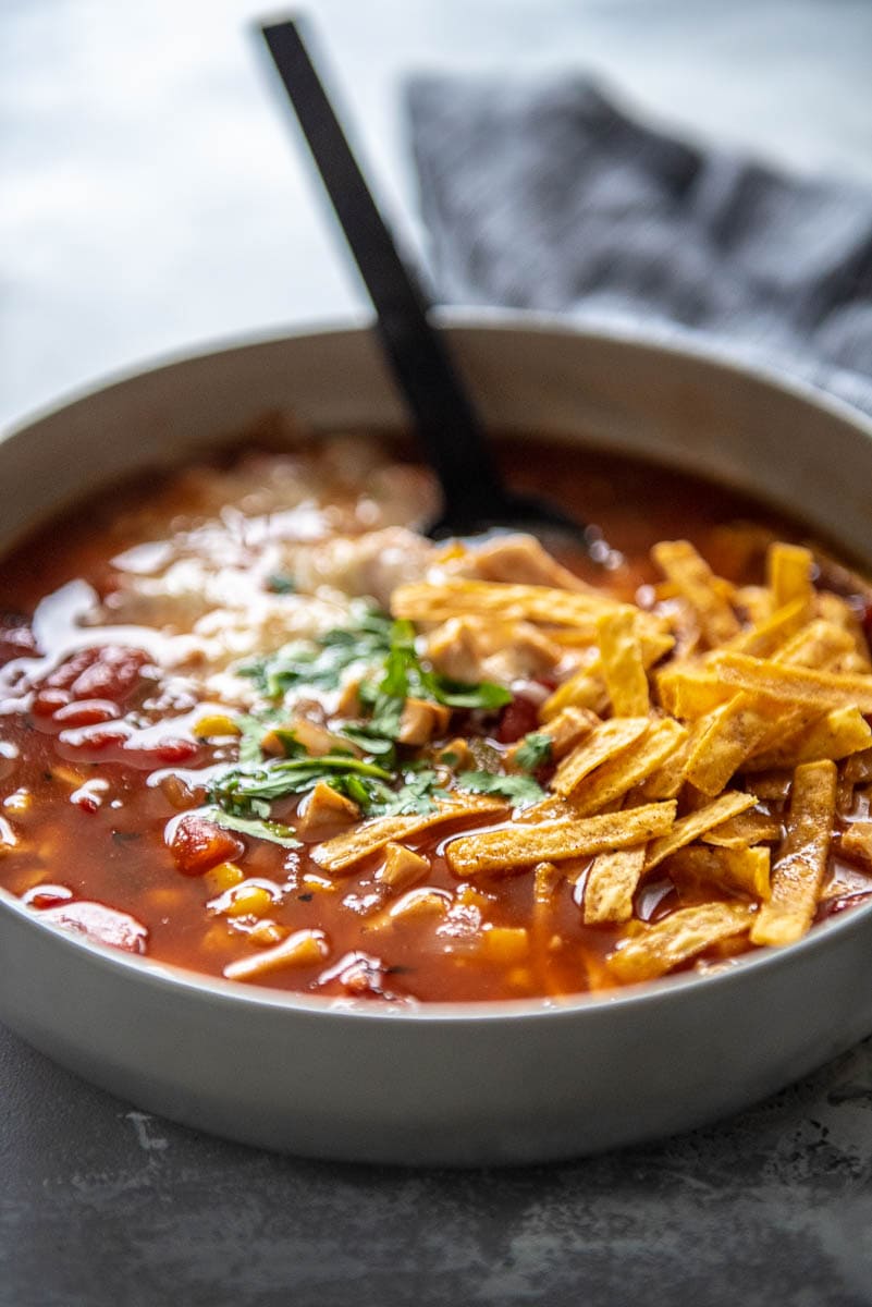 bowl of tortillas soup with cheese and tortilla strips