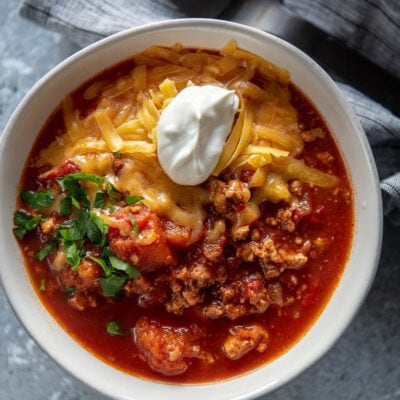 white bowl of turkey chili topped with sour cream