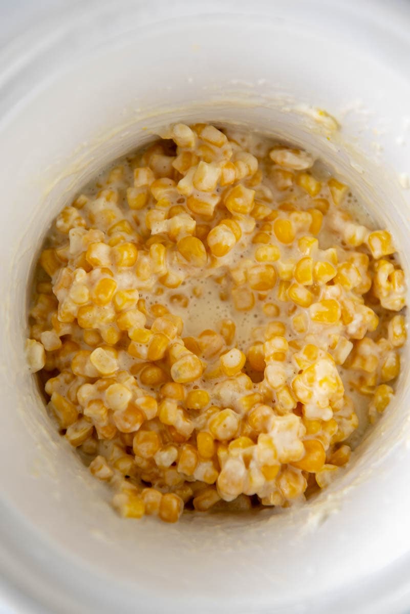 creamed corn in a white slow cooker