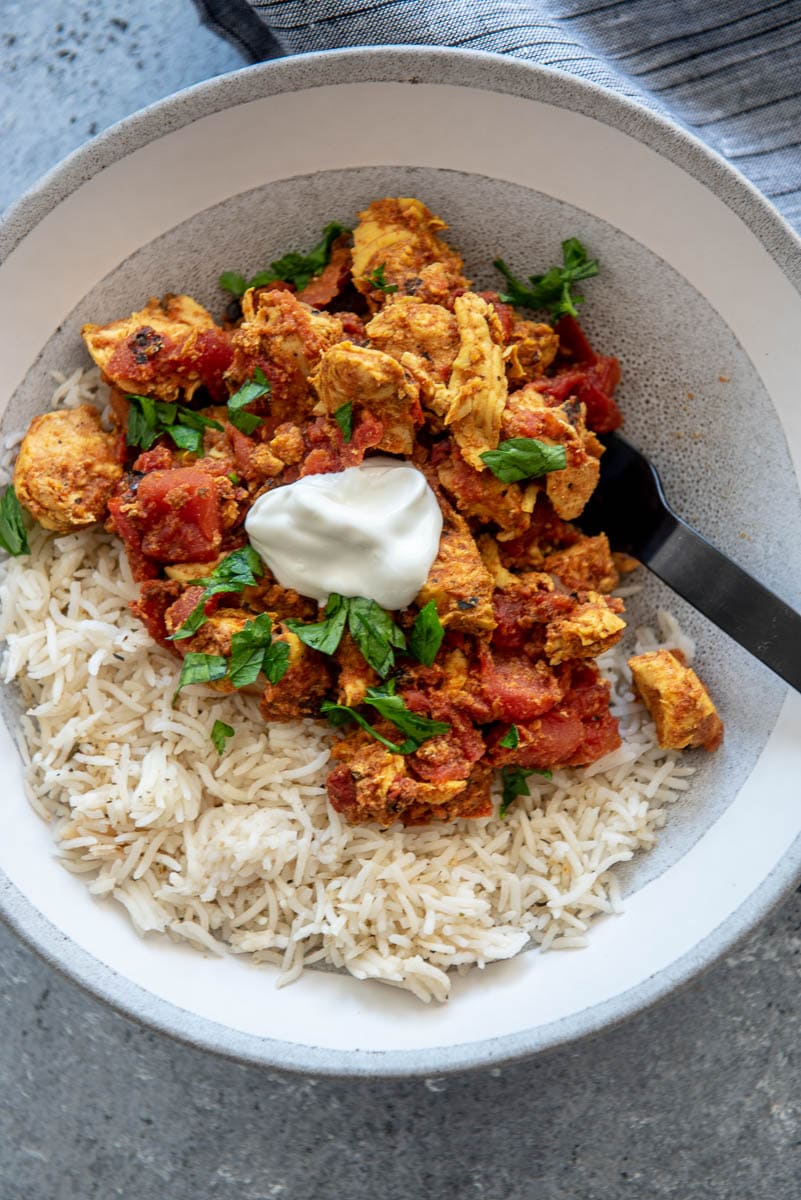 gray and white bowl filled with rice and moroccan chicken