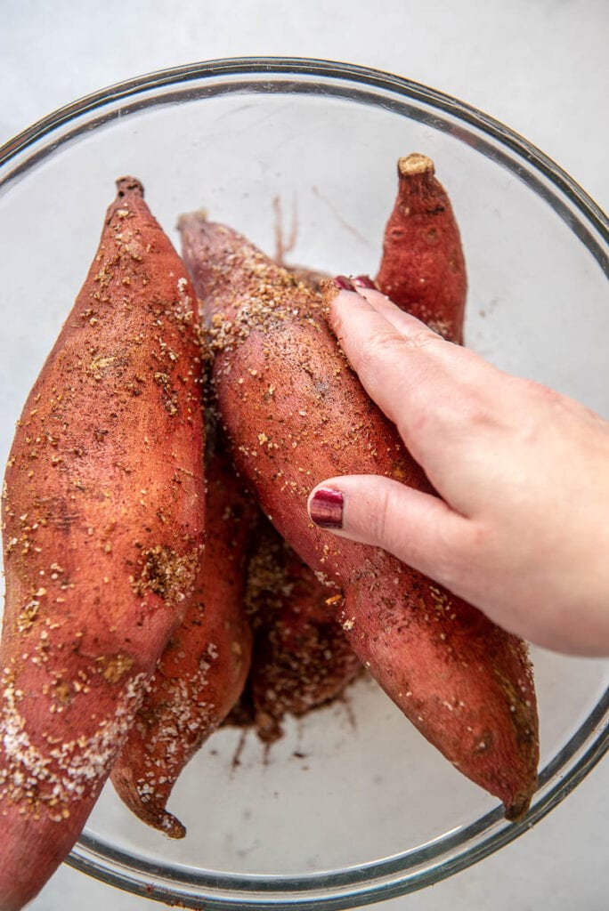 rubbing seasoning into sweet potatoes