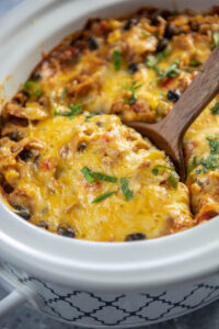 taco casserole with wooden spoon in oval mini casserole slow cooker