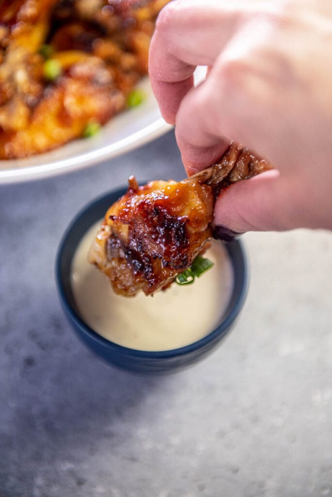 dipping chicken wing in blue cheese dressing