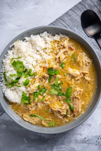 chicken chili verde in large gray bowl with rice and cilantro