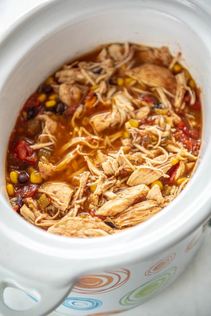 shredded mexican chicken in white slow cooker