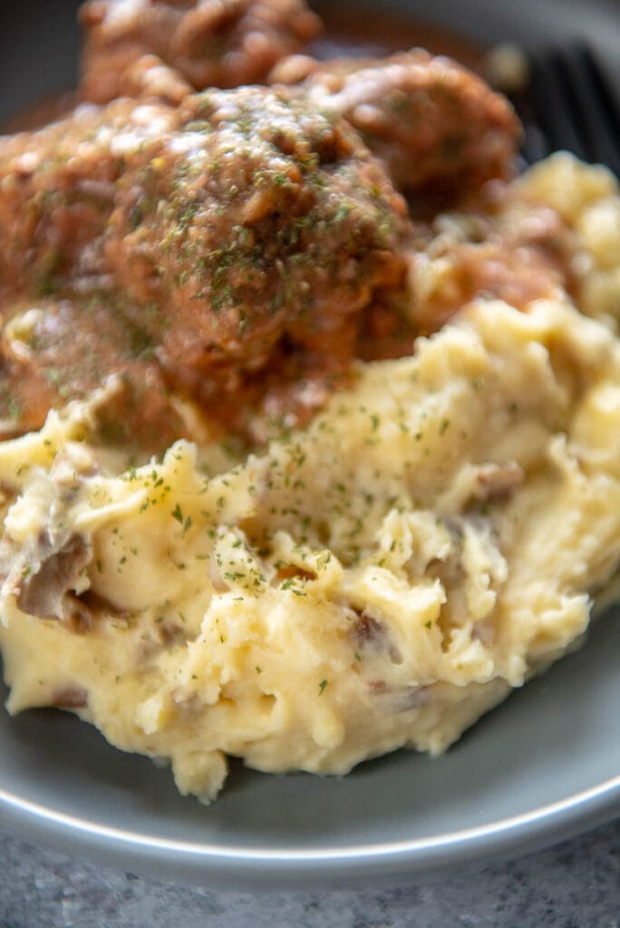 mashed potatoes next to meatballs on plate