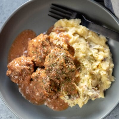 meatballs and mashed potatoes in gray bowl with gravy