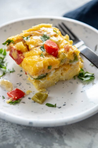 square slice of Denver omelette casserole on a white with blue speckles plate