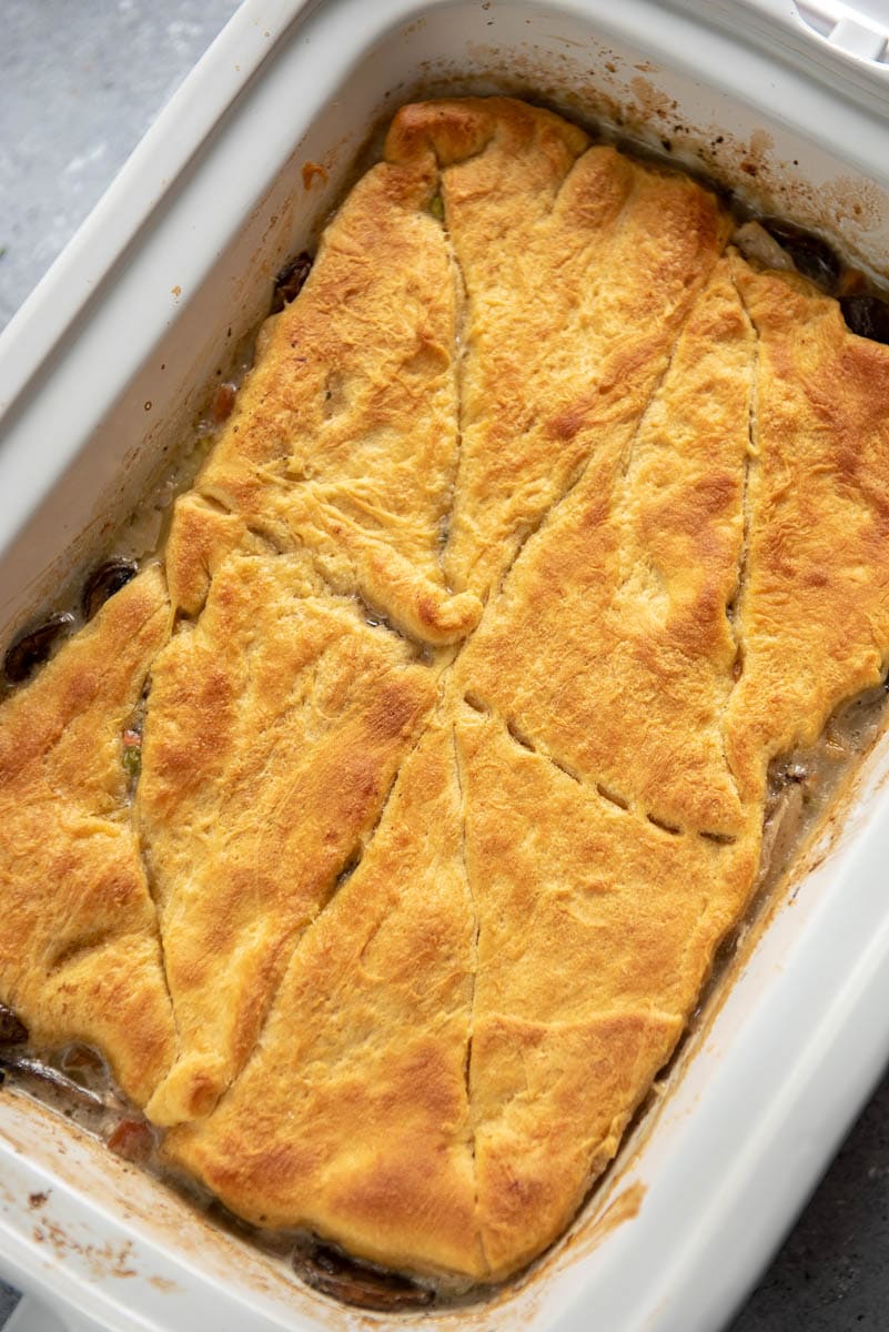 overhead view of chicken pot pie in casserole slow cooker with crescent roll topping