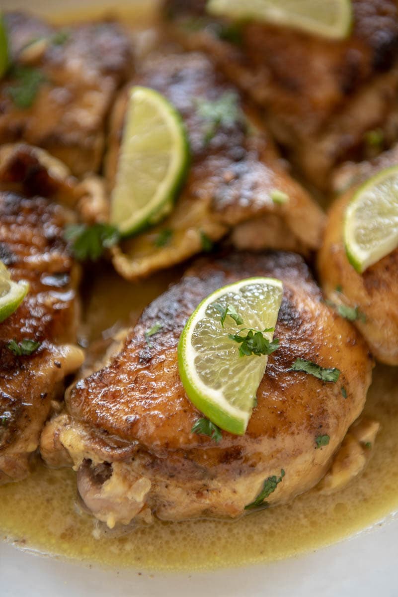 chicken thighs in coconut lime sauce with lime wedges on top