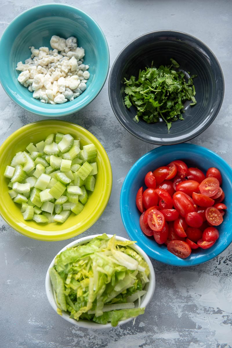 onions, bell peppers, tomatoes, and lettuce in bowls