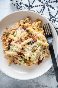 sausage pasta bake on a white plate with fork