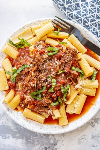 beef ragu on a white plate with a fork