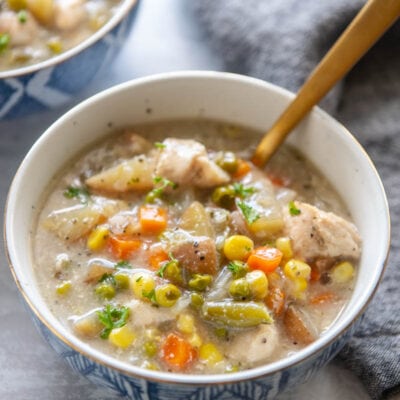 bowl of chicken pot pie soup with a spoon