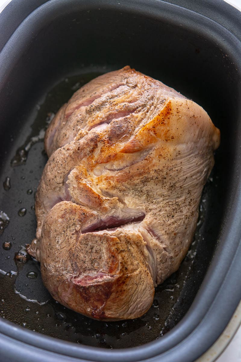 pork shoulder and seasonings in a slow cooker