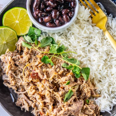 cuban pork on a plate with black beans and rice