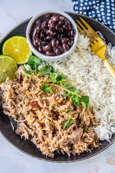 cuban pork on a plate with black beans and rice