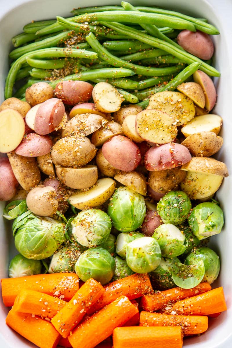 raw fall veggies with seasoning in a pan