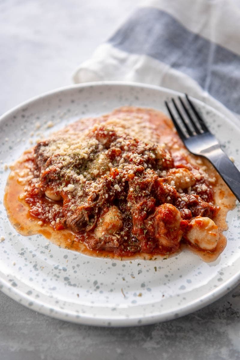 beef ragu on a white plate with fork