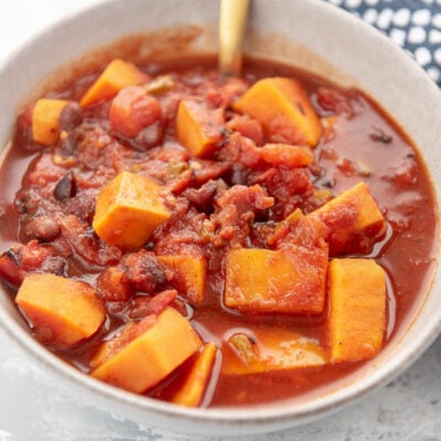 sweet potato chili in a white bowl with spoon