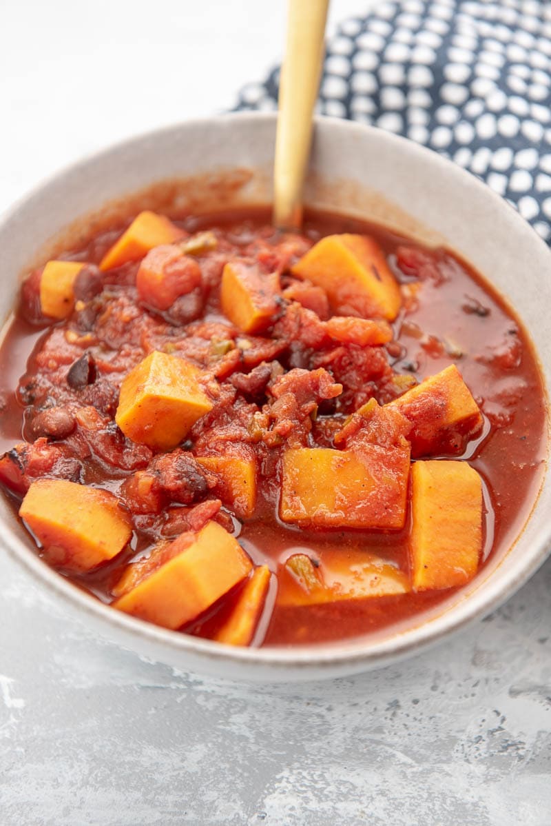 sweet potato chili in a white bowl with spoon