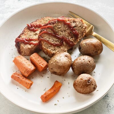 turkey meatloaf on a plate with carrots and potatoes
