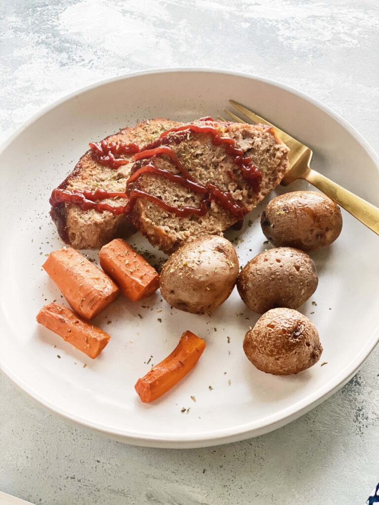 turkey meatloaf on a plate with carrots and potatoes