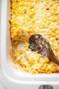 spoon scooping cheesy corn casserole
