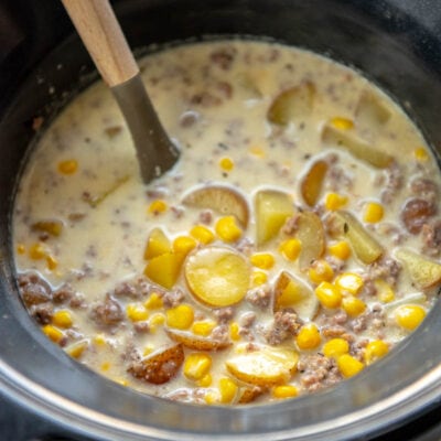 slow cooker with ladle and sausage and potato soup