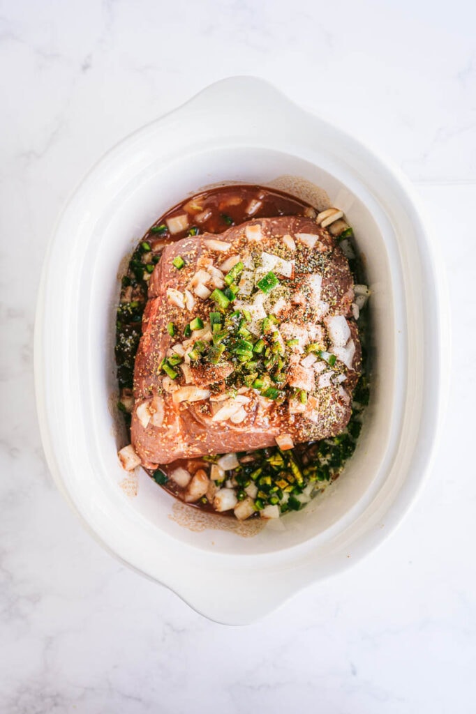 uncooked carnitas in a slow cooker