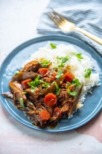 ginger pork on a blue plate with a fork