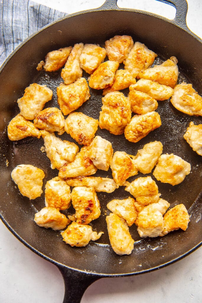 coated chicken pieces in a fry pan