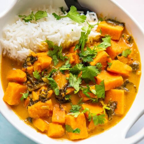 sweet potato curry in a white bowl with spoon