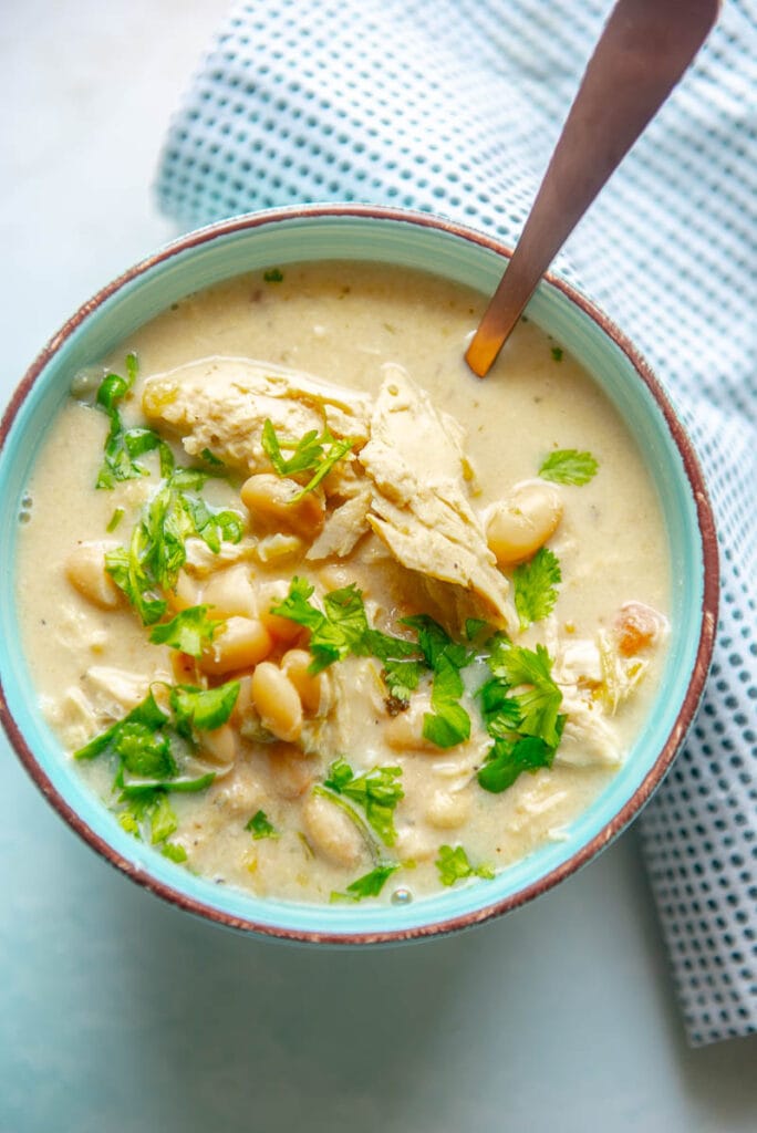 white chicken chili in a bowl with spoon