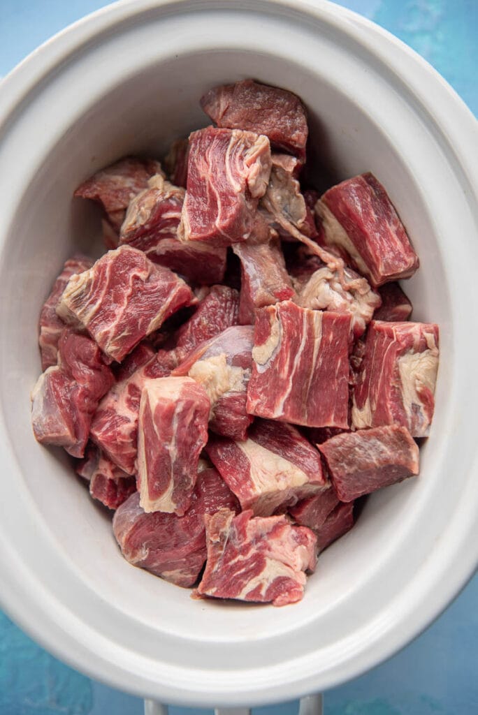 beef stew meat in oval white slow cooker